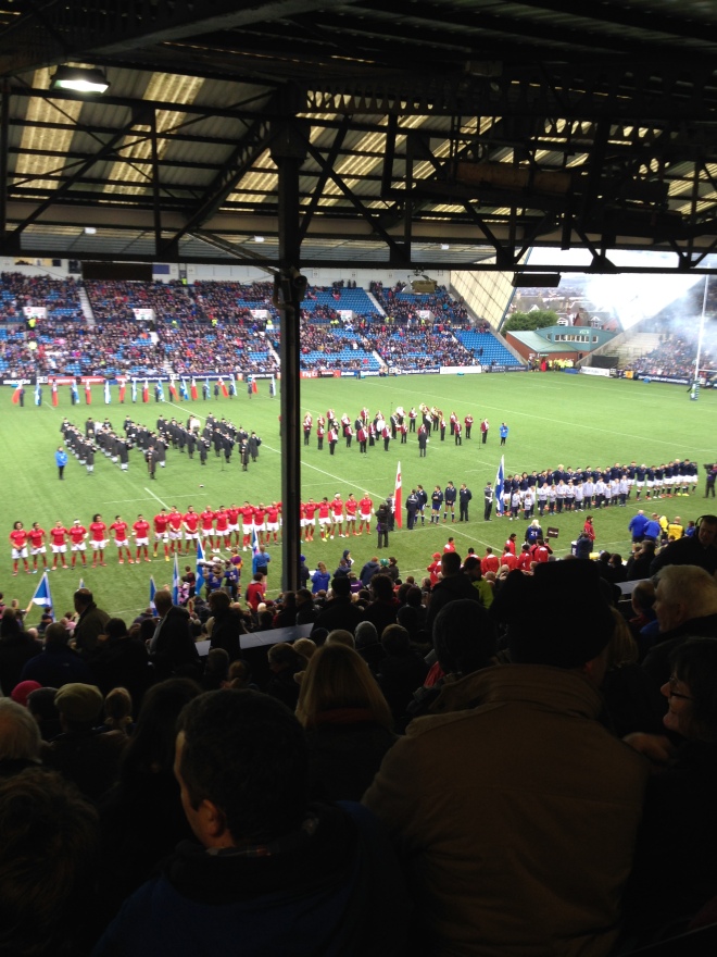 The teams line up to sing their national anthems.